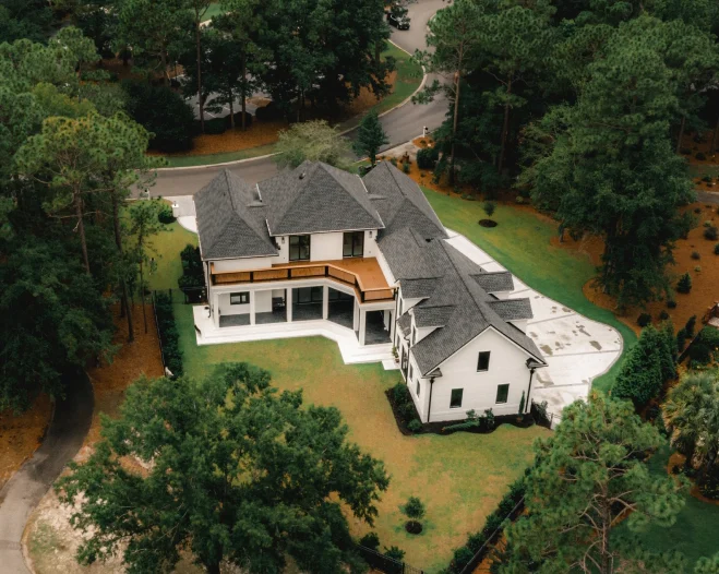 cutom house built on a wide and open lot surrounded by tall trees